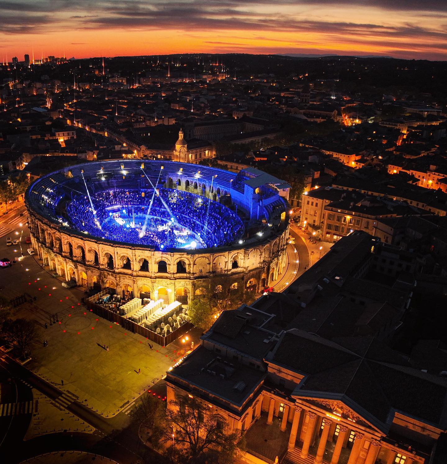 An arena illuminated at night, seen from the air in images associated with Boris Brejcha’s live session