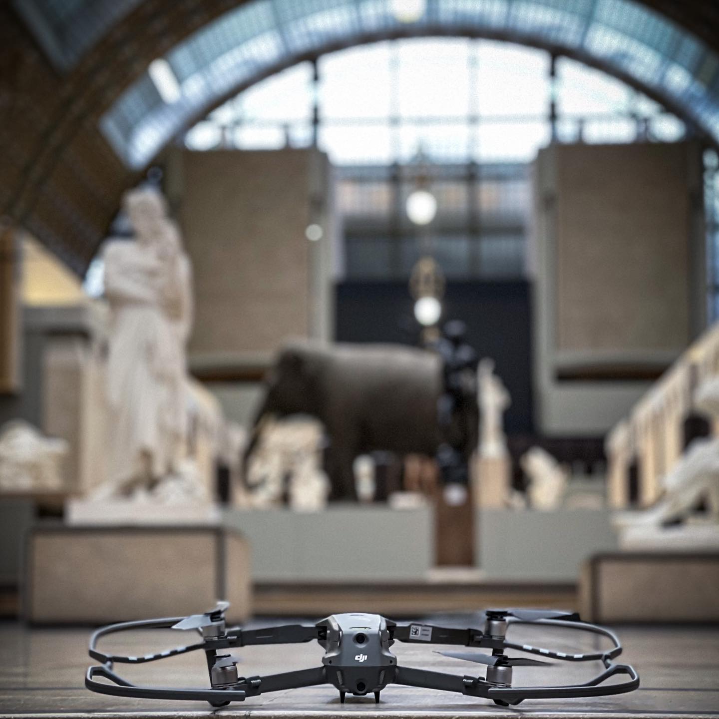 A drone in the foreground of the Musée d’Orsay nave, in front of the sculptures and large clock