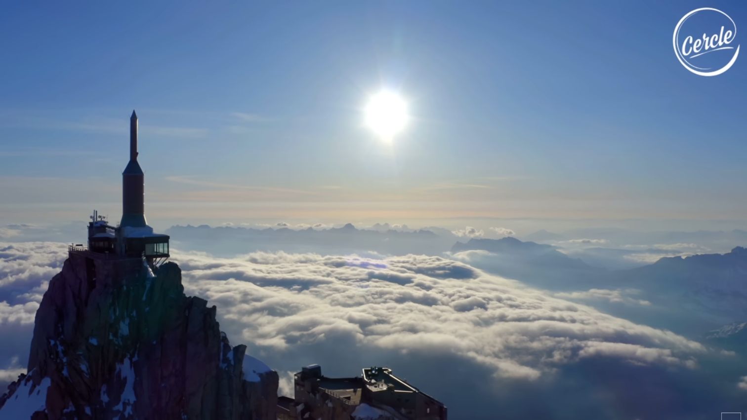 The Aiguille du Midi above a sea of clouds, with sunlight on the Mont Blanc massif